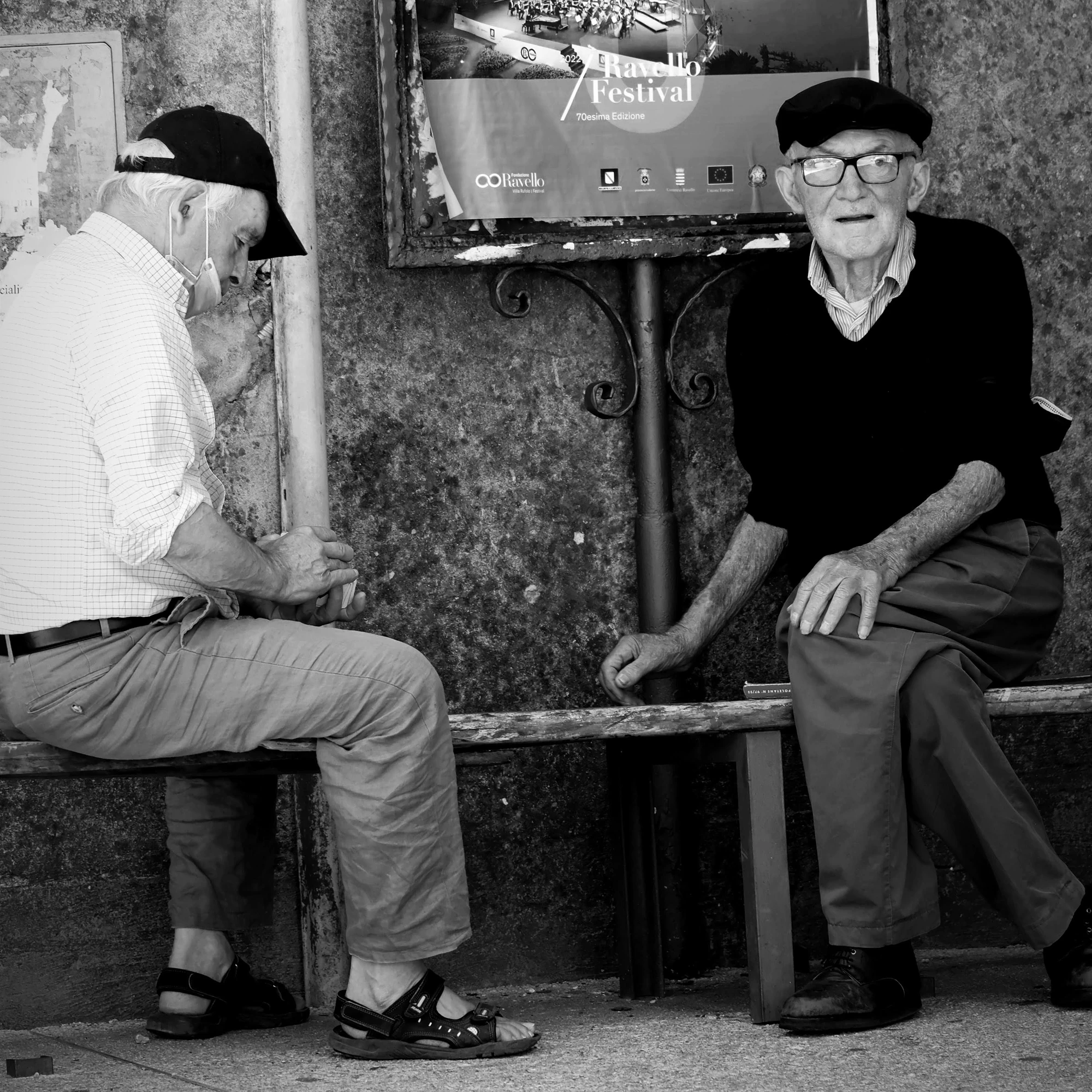 Dos hombres conversan junto a una pared