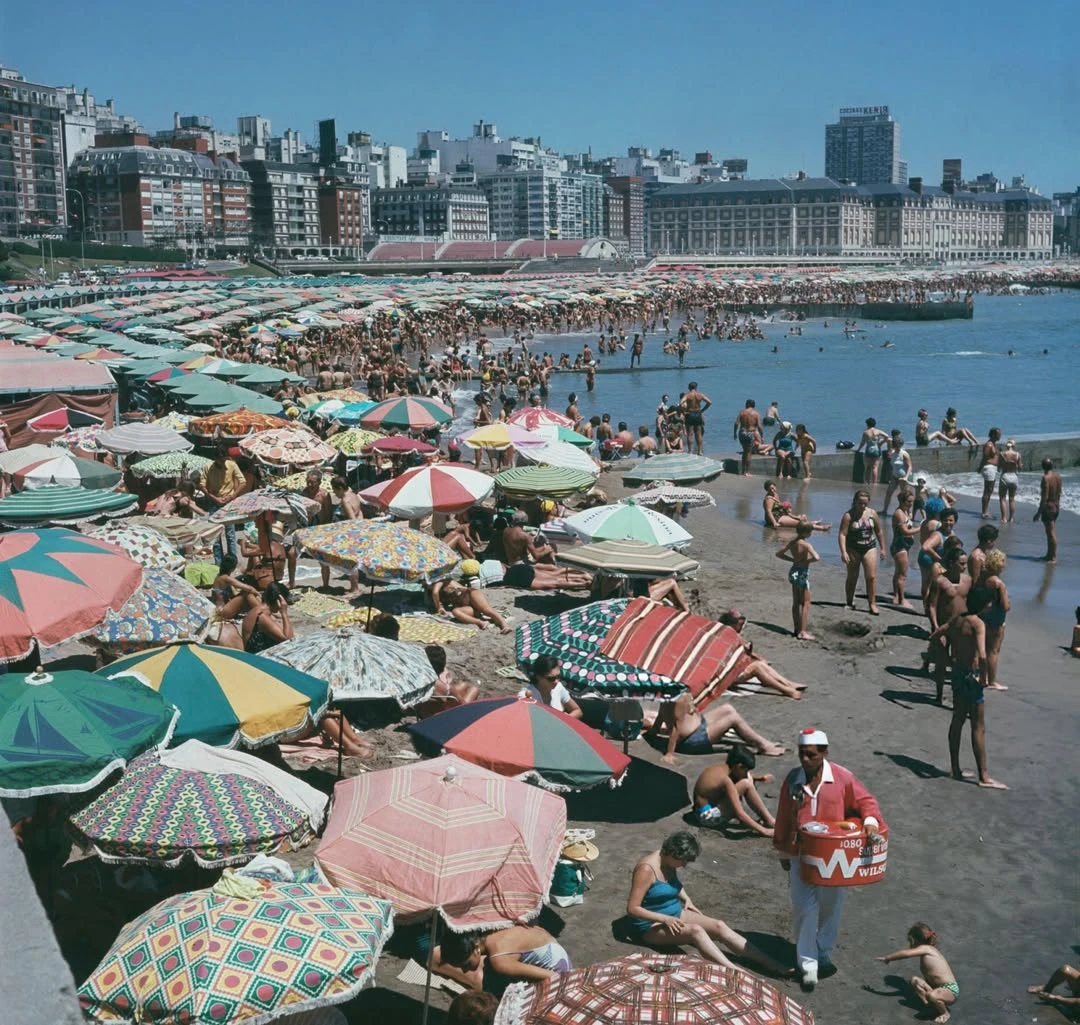 Una playa llena de sombrillas