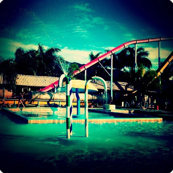 Una piscina y un tobogán en una imagen de verano
